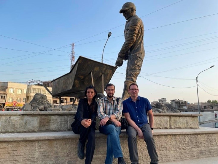 Dr Inna Rudolf, photographer Ali al-Baroodi, and Dr Craig Larkin by a statue celebrating the role of locals in rebuilding Mosul after its liberation